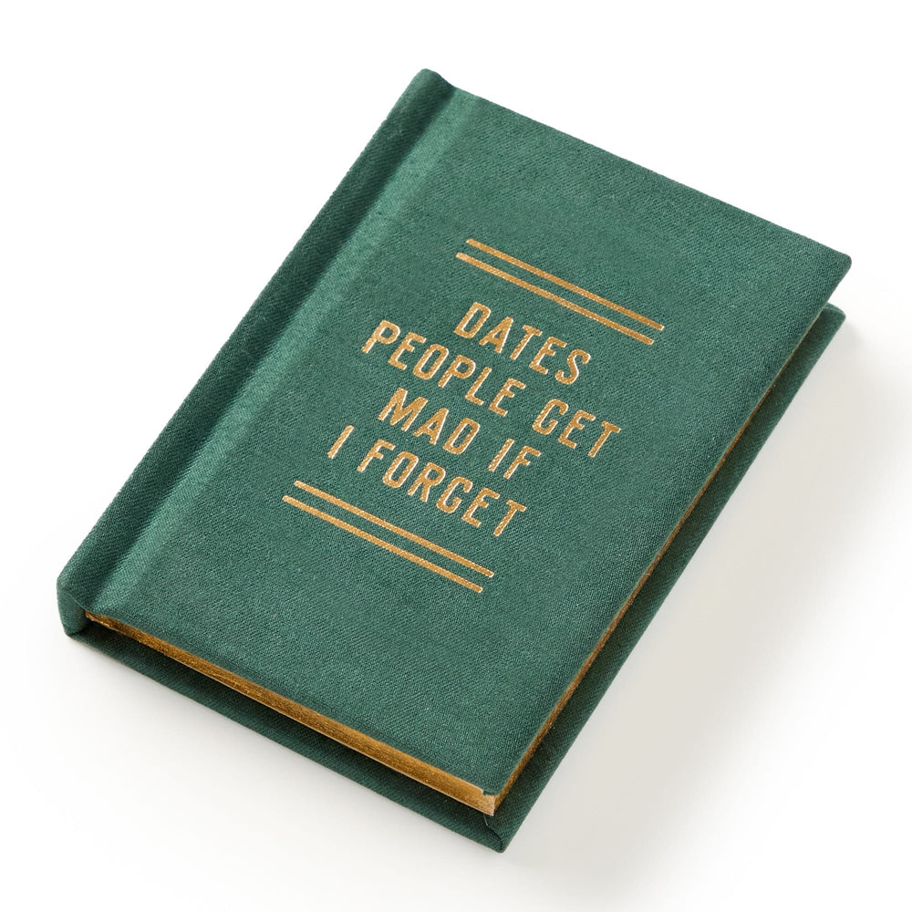 A hard-bound green Dates People Get Mad If I Forget Tiny Diary by Brass Monkey, with gilded page edges and gold cover text, lies slightly tilted on a white surface.