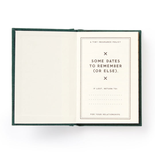 A hard-bound Brass Monkey Dates People Get Mad If I Forget Tiny Diary lies open with gilded pages: one blank, the other titled A Tiny Insurance Policy—Some Dates to Remember (Or Else), plus a spot for contact info if lost.