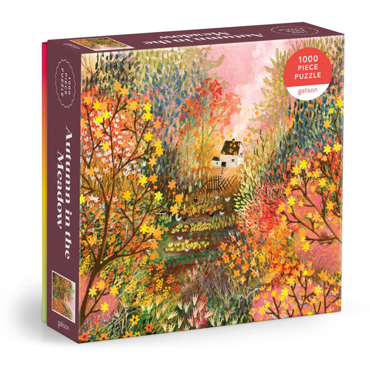 The Laivi Põder Autumn in the Meadow 1000 Piece Puzzle features an illustration of a cozy house amid colorful autumn trees, showcasing vibrant oranges, yellows, greens, and detailed botanical foliage.