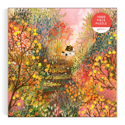 The Laivi Põder Autumn in the Meadow 1000 Piece Puzzle features a vibrant scene of a small white house amid autumn trees and flowers, exquisitely detailed against a pink sky.