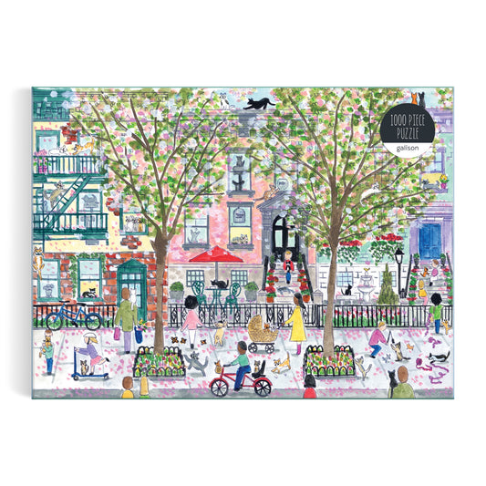Fans of puzzles will enjoy the Michael Storrings Cats in the City 1000 Piece Puzzle, featuring lively city sidewalks, blooming trees, brownstones, café tables, and a black cat—an energetic and colorful springtime scene by Michael Storrings.