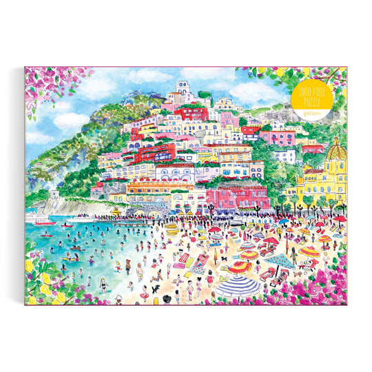 The Michael Storrings Coast of Italy 1000 Piece Puzzle features a vibrant illustration of the Amalfi Coast, with colorful hillside houses, lively beaches, turquoise waters, and flowers—an ideal gift for art lovers.