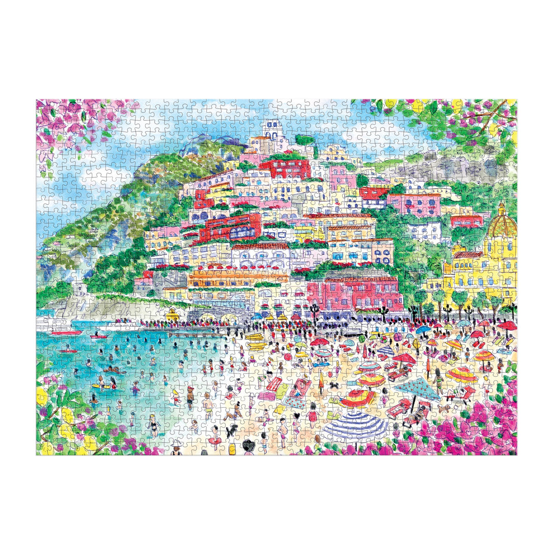Vibrant illustration of Positano, Italy on the Michael Storrings Coast of Italy 1000 Piece Puzzle; colorful houses dot a green hillside under a blue sky, framed by pink flowers—a perfect art lover gift from Michael Storrings.
