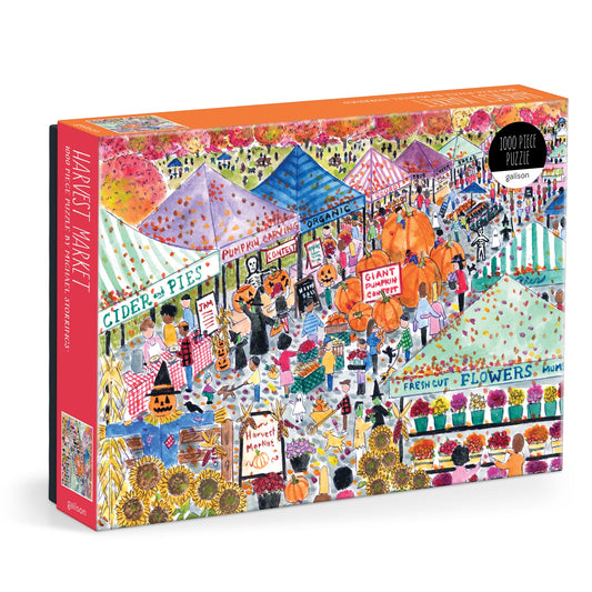 The Michael Storrings Harvest Market 1000 Piece Puzzle by Michael Storrings features a vibrant, festive scene with people, autumn produce, tents, pumpkins, fresh flowers, and signs for cider and organic goods.