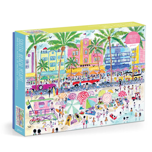 The Michael Storrings South Beach Miami 1000 Piece Puzzle by Michael Storrings features a vibrant illustration of South Beach with palm trees, art deco buildings, beachgoers, umbrellas, and street cars.