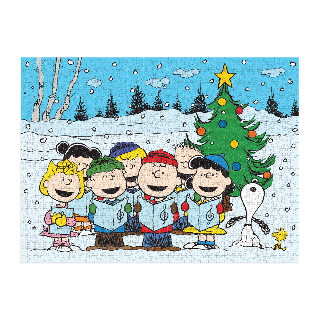 Charlie Brown, Lucy, Linus, Sally, Snoopy, and Woodstock from Peanuts stand singing carols by a Christmas tree in the snow on the Peanuts Christmas Caroling 1000 Piece Puzzle by Peanuts Worldwide, LLC.