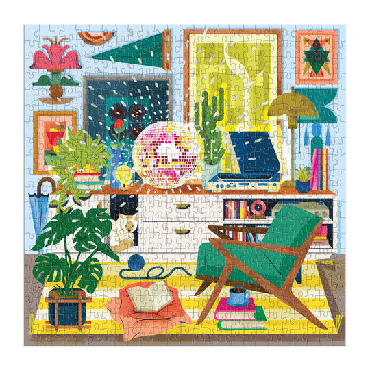 Once completed, the Disco Life 500 Piece Foil Puzzle by EurekartStudio displays a vibrant living room scene with plants, books, wall art, a record player, green chair, and yellow rug—combining modern elegance and retro style.