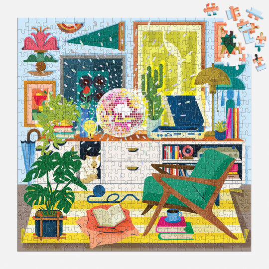 The Disco Life 500 Piece Foil Puzzle by EurekartStudio features a vibrant living room with plants, vinyl player, books, wall art, disco ball, and green chair. Some pieces are still outside the top right corner, showcasing its retro charm.