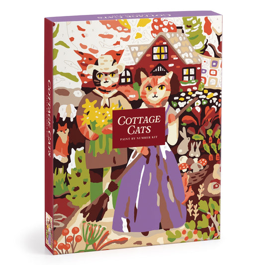 The Cottage Cats 9 x 12 Paint by Number Kit by Anja Riebensahm features two cats in traditional clothes standing before a cozy cottage, surrounded by colorful plants and flowers on the box illustration.