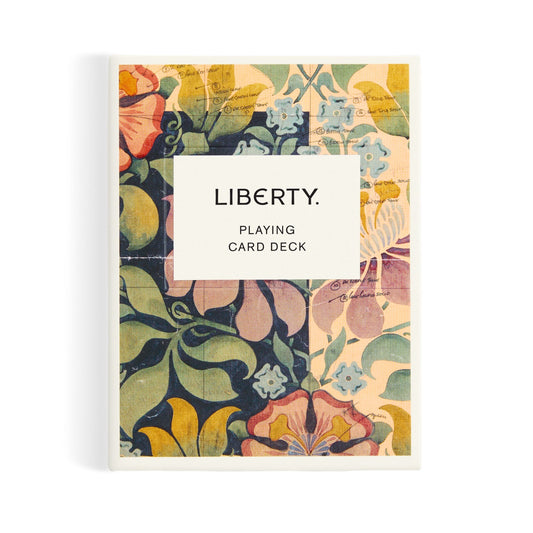 The Liberty London Archive Playing Card Deck features a vibrant floral design in yellow, pink, green, and blue, inspired by textile heritage, with a white center label reading LIBERTY. PLAYING CARD DECK.