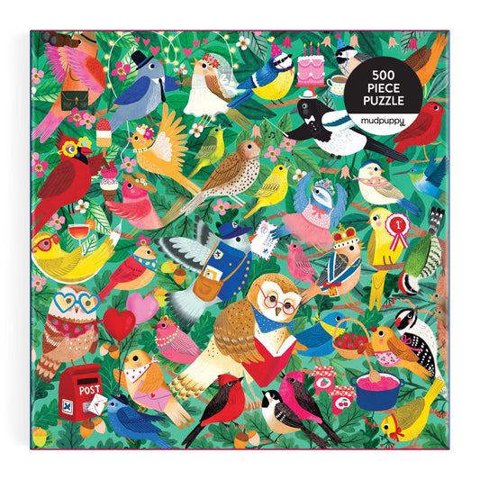 Explore the Birding Around 500 Piece Puzzle by Rebecca Jones, showcasing lively birds in bright outfits amid lush leaves and flowers, with some holding fun objects—a vibrant box perfect for puzzle lovers.