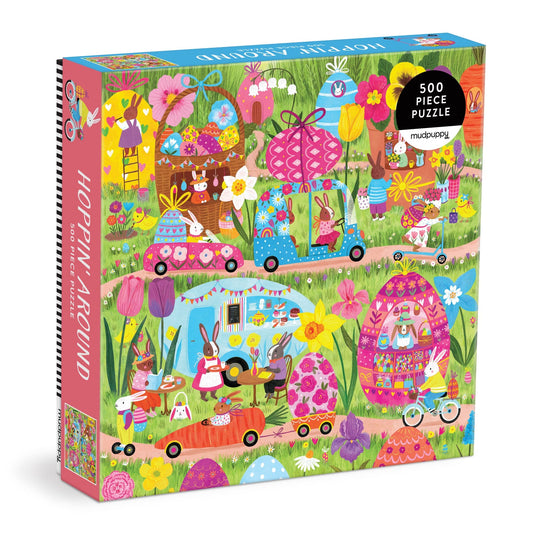 Enjoy springtime fun with the Hoppin' Around 500 Piece Family Puzzle by Jenny Miriam—featuring charming rabbits biking and driving through vibrant flowers, whimsical homes, and a lively outdoor market. Perfect for families!.