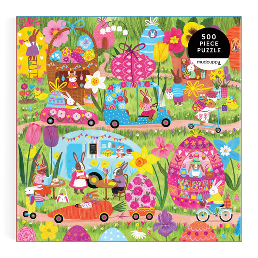 Enjoy Jenny Miriam's Hoppin' Around 500 Piece Family Puzzle, featuring rabbits celebrating spring among giant flowers and Easter eggs, riding bikes, driving cars, and picnicking. Perfect for family fun!.