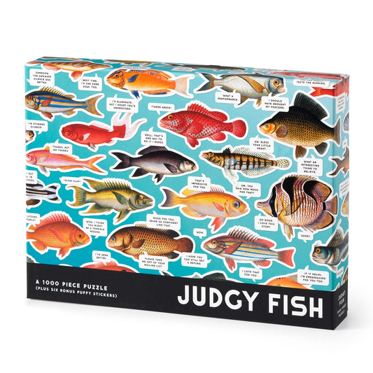 The Brass Monkey Judgy Fish 1000 Piece Puzzle features colorful illustrated fish on a blue background, each with a witty, sarcastic speech bubble. Made from recycled materials for eco-friendly fun.