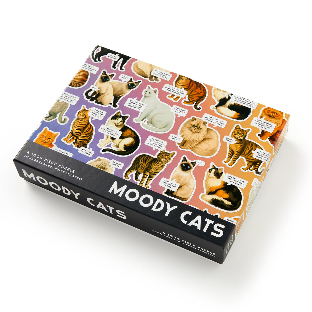 The Brass Monkey Moody Cats 1000 Piece Puzzle features illustrations of cats in different moods and fur patterns with witty captions, making it a fun jigsaw for cat lovers and puzzle fans.