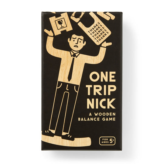 The Brass Monkey One Trip Nick Wooden Balance Game box shows a worried man balancing grocery items. The black and tan packaging displays wood game pieces and notes it’s for ages 5 and up.