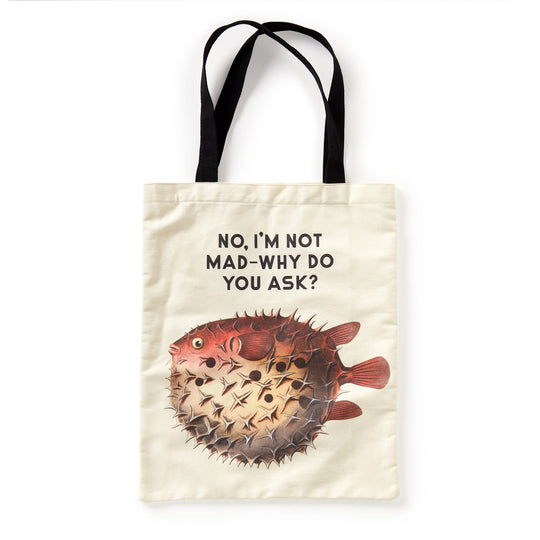 The Brass Monkey Judgy Fish Canvas Tote is a beige bag with black handles, featuring a pufferfish graphic and the funny phrase NO, IM NOT MAD—WHY DO YOU ASK? above the fish.