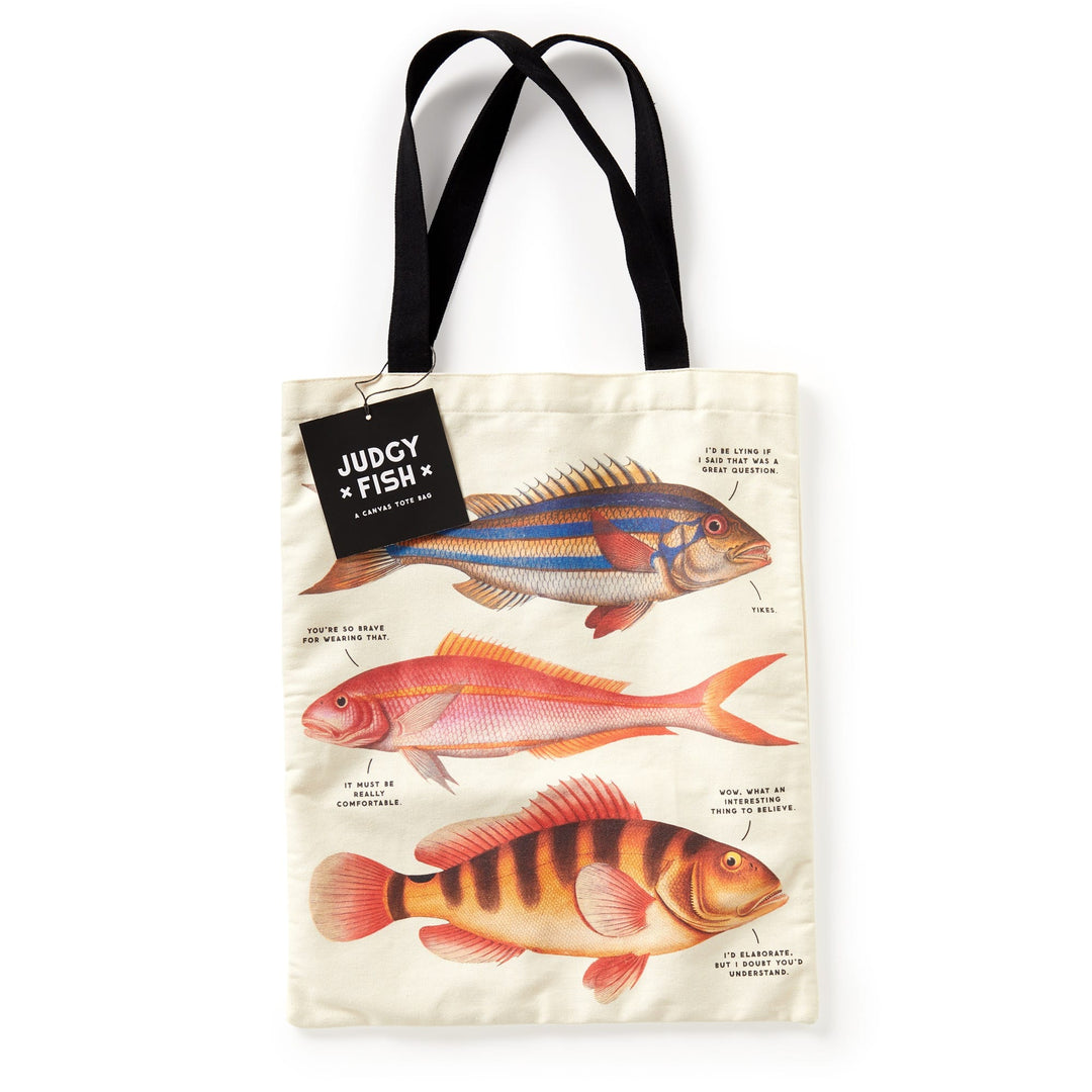 The Judgy Fish Canvas Tote by Brass Monkey features cream-colored canvas with illustrated fish and witty captions, black handles, and a “JUDGY FISH” tag near the top. Perfect for fans of playful, vintage-inspired fish art.