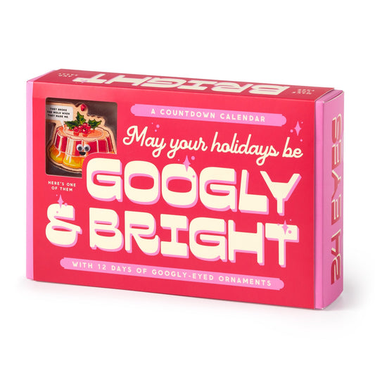 The Brass Monkey Googly & Bright Holiday Ornament Countdown Calendar is a pink and red box with 12 playful googly-eyed ornaments, festive art, and the message “May your holidays be Googly & Bright.”.