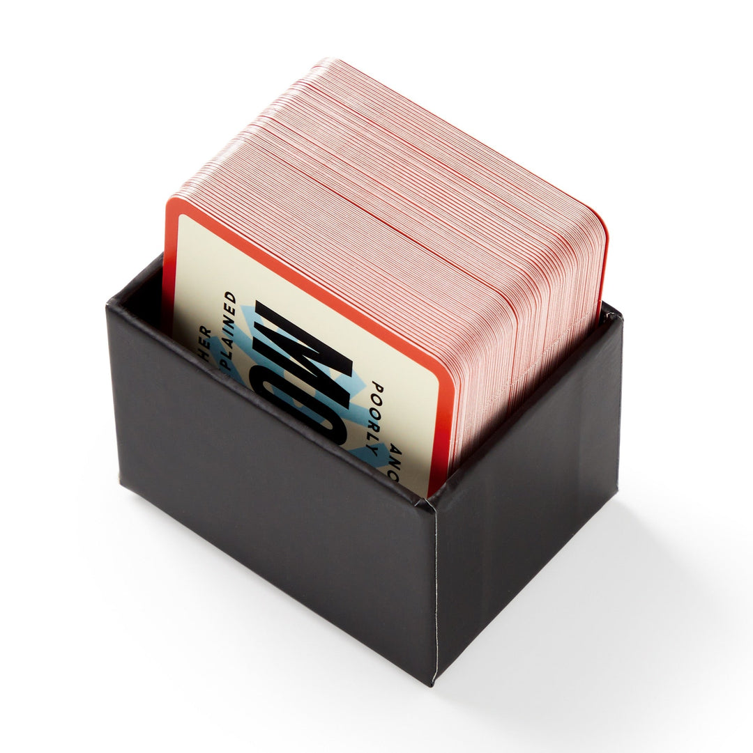 Mini Poorly Explained Movies - Holiday Edition by Brass Monkey features a stack of red-edged playing cards in a sleek black box, perfect for holiday movie nights. The top card shows bold black text on a blue and white background.