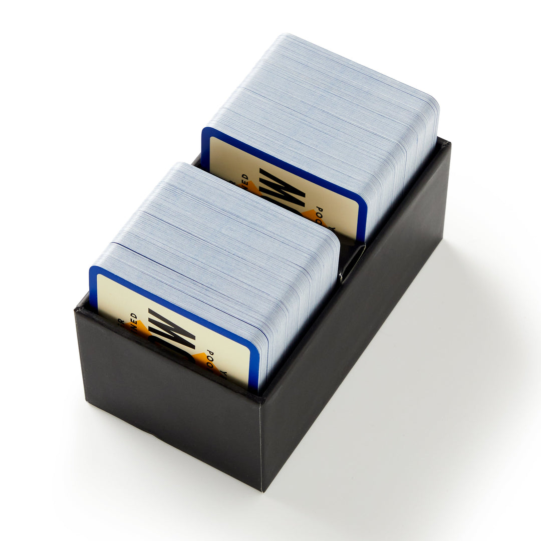 A black box from Brass Monkey containing two stacks of blue-edged cards with zigzag designs and "PO" text—an ideal party game for pop culture fans: the Poorly Explained TV Shows Game.