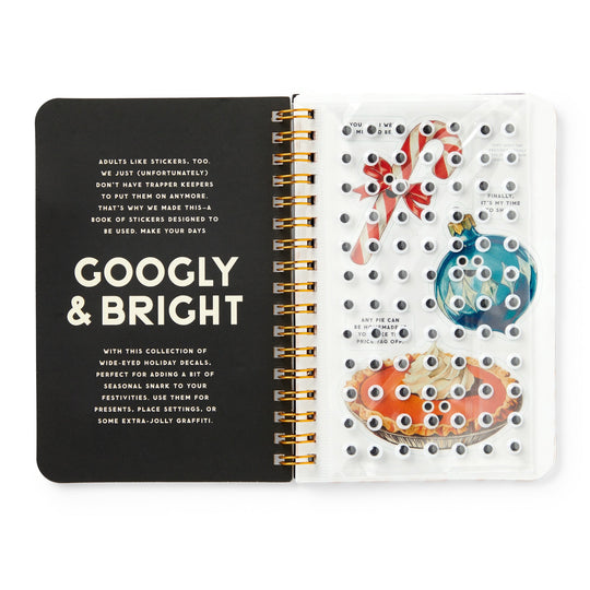 The Googly & Bright Holiday Sticker Book by Brass Monkey features spiral-bound pages with festive stickers—like candy canes, ornaments, and big holiday treats—all accented with playful googly eyes for extra cheer.