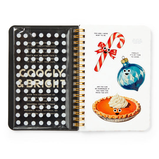 The Brass Monkey Googly & Bright Holiday Sticker Book features a polka-dot cover with gold text, a clear pocket inside, and festive stickers—candy cane, blue ornament, and pumpkin pie—all with googly eyes and cheerful faces.