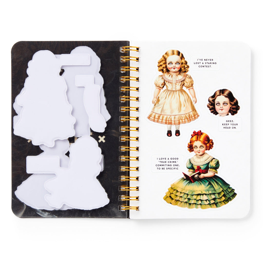 An open Brass Monkey Haunted Dolls Sticker Book displays blank paper cutouts on the left and two wide-eyed, curly-haired illustrated dolls in dresses on the right—perfect for adding your favorite ghostly stickers.