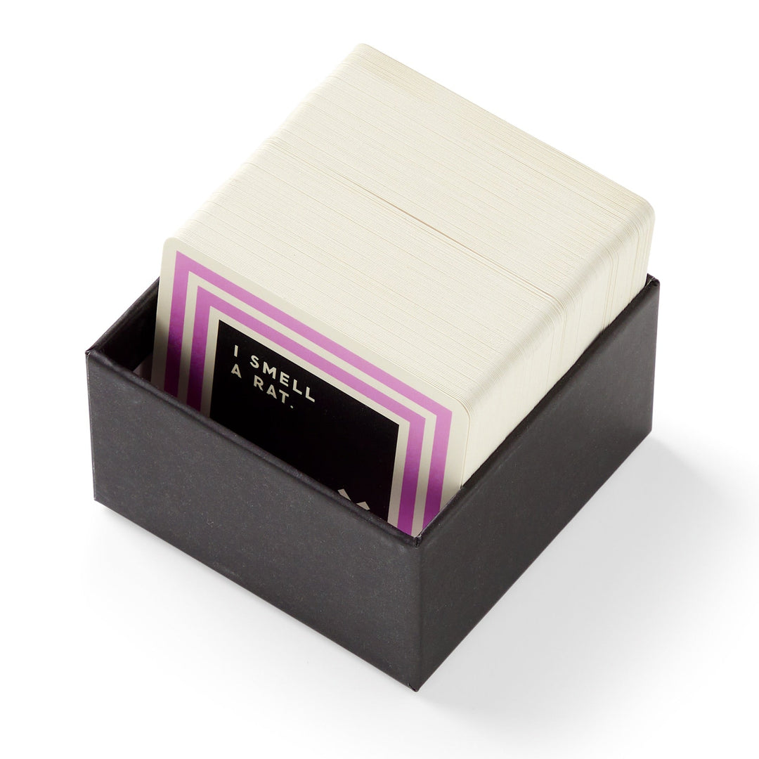 A black box by Brass Monkey holds a stack of Useless Animal Trivia cards, with the top card showing a purple border and the text I SMELL A RAT—ideal for fans of odd animal facts or trivia.