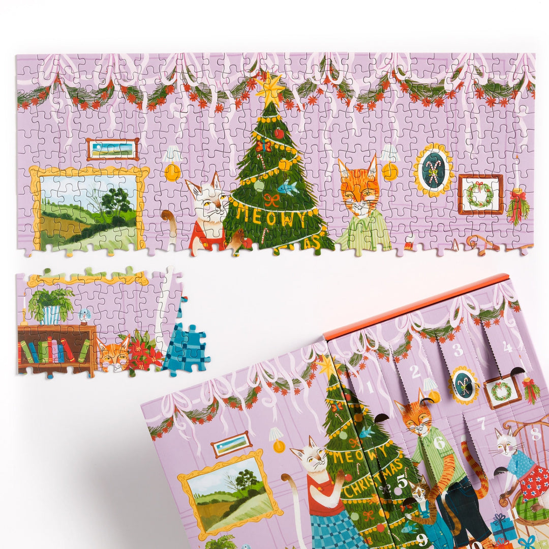 A partially completed Joanna Letz Meowy Christmas 12 Days of Puzzles 500 Piece Countdown shows playful cats, a decorated tree, garlands, and framed pictures. One large section and a few pieces are missing; the festive puzzle box is also visible.
