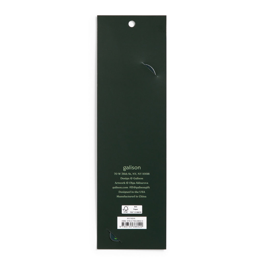 The image shows the back of a long, dark green rectangular package for the World of Mushrooms Paper Bookmark by Olga Akbarova, with a hanging hole at the top. Branding, contact info, and a barcode are near the bottom. Two small tears are visible.