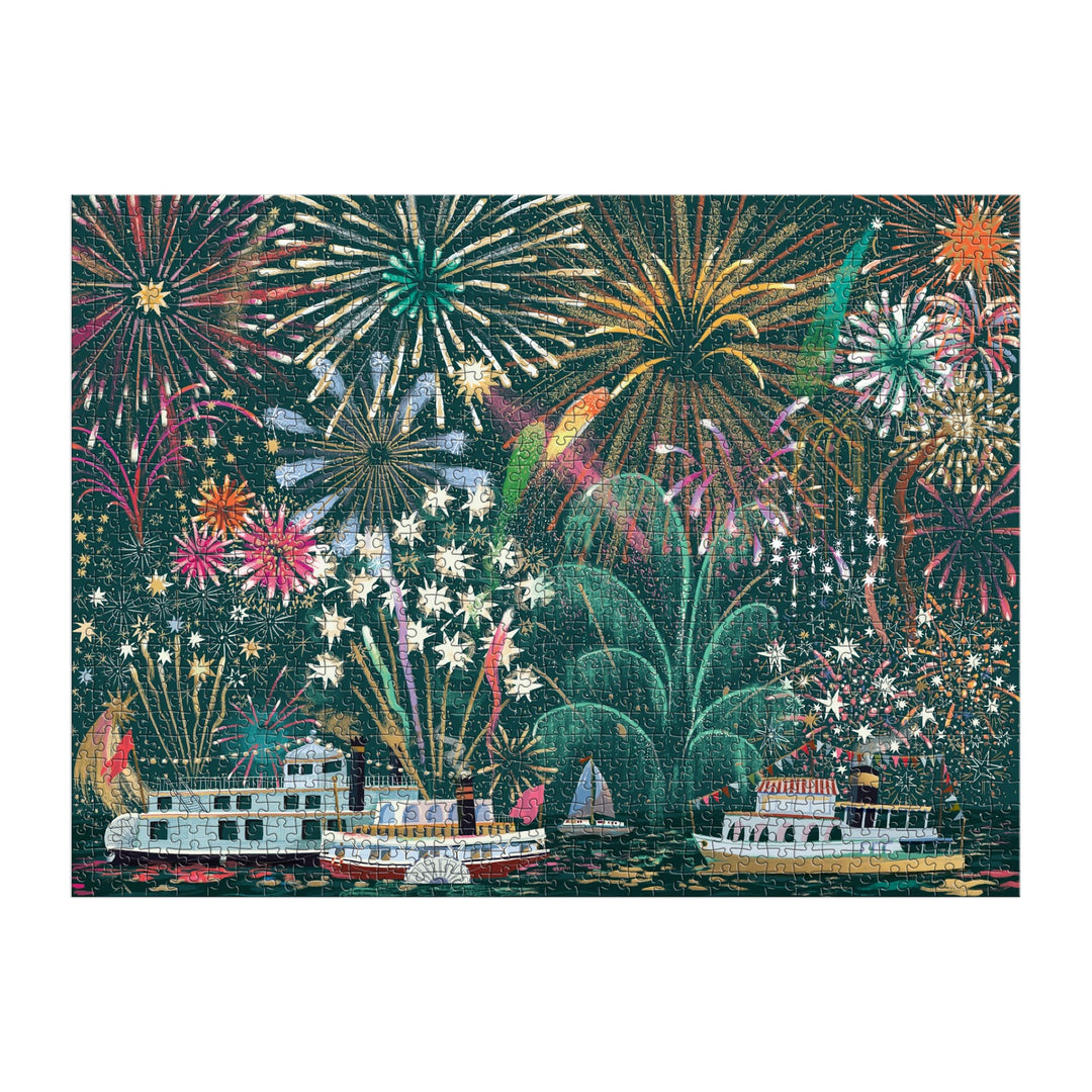 The Fireworks Jubilee 1000 Piece Foil Puzzle by Sarah Long features colorful fireworks bursting above decorated boats, with shimmering reflections on dark water for a festive celebration scene.