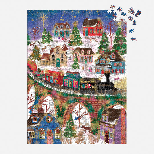 The Joy Laforme Twinkletown Express 1000 Piece Foil Puzzle by Joy Laforme features a snowy village with decorated houses, a train on a stone bridge, and a starry sky. Some pieces are missing from the upper right corner.