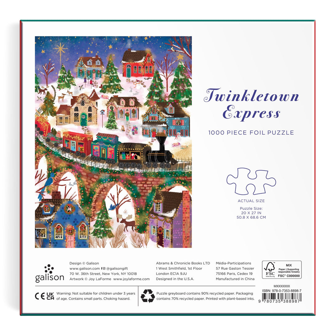 Back of the Joy Laforme Twinkletown Express 1000 Piece Foil Puzzle box features a festive winter village with decorated houses, snowy trees, a train, and people. "Twinkletown Express" title, puzzle size, and Joy Laforme brand details are visible.