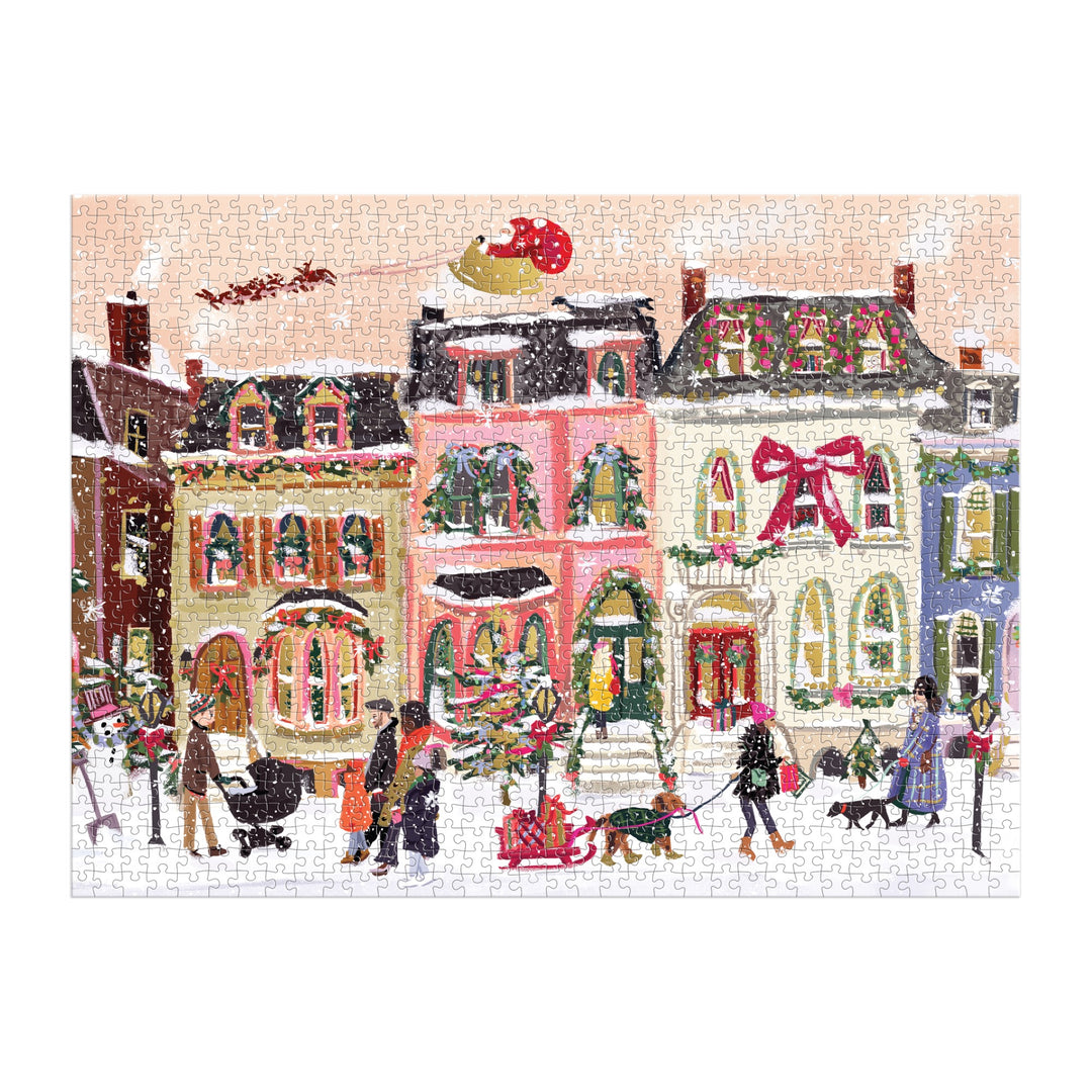 The Nysha Lilly Snowfall on Main Street 1000 Piece Foil Puzzle features people and dogs in a festive, snowy village as Santa’s sleigh flies above. Shiny foil accents highlight wreaths and bows on the decorated buildings.