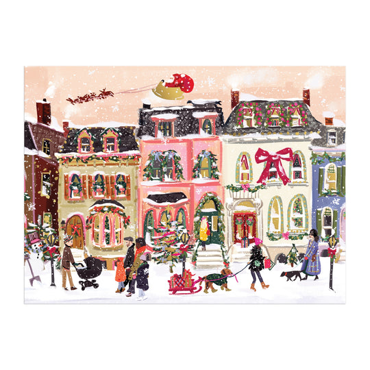The Snowfall on Main Street 1000 Piece Foil Puzzle by Nysha Lilly features a festive winter scene with people walking dogs and decorating a Christmas tree, colorful snowy houses, and Santa’s sleigh above.