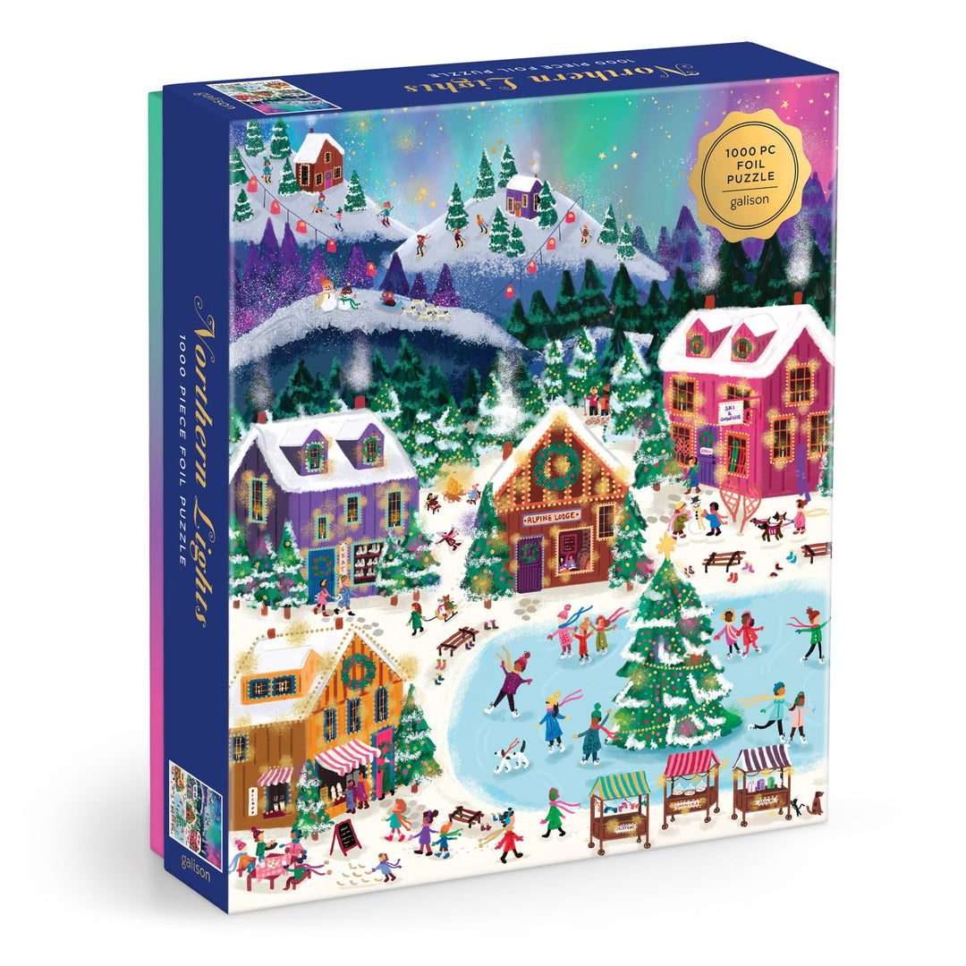 The Joy Laforme Northern Lights 1000 Piece Foil Puzzle features a colorful winter village with snow-covered houses, ice skaters, market stalls, and an aurora-lit night sky.