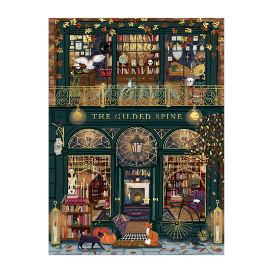 Experience Sally Wilson’s The Gilded Spine 1000 Piece Foil Puzzle, featuring a whimsical bookstore with two book-filled floors, arched windows, golden accents, fall leaves, and cozy autumn vibes—plus charming cats outside.