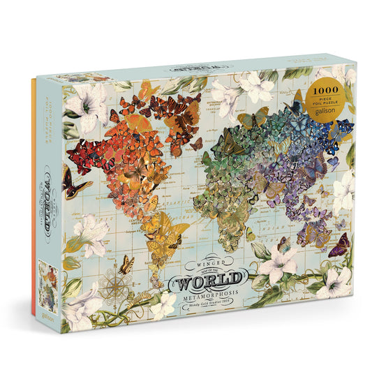 The Wendy Gold Winged Metamorphosis 1000 Piece Foil Puzzle features a world map made of colorful butterfly wings by continent, a pale floral background, and comes in a box titled Winged World: Metamorphosis.