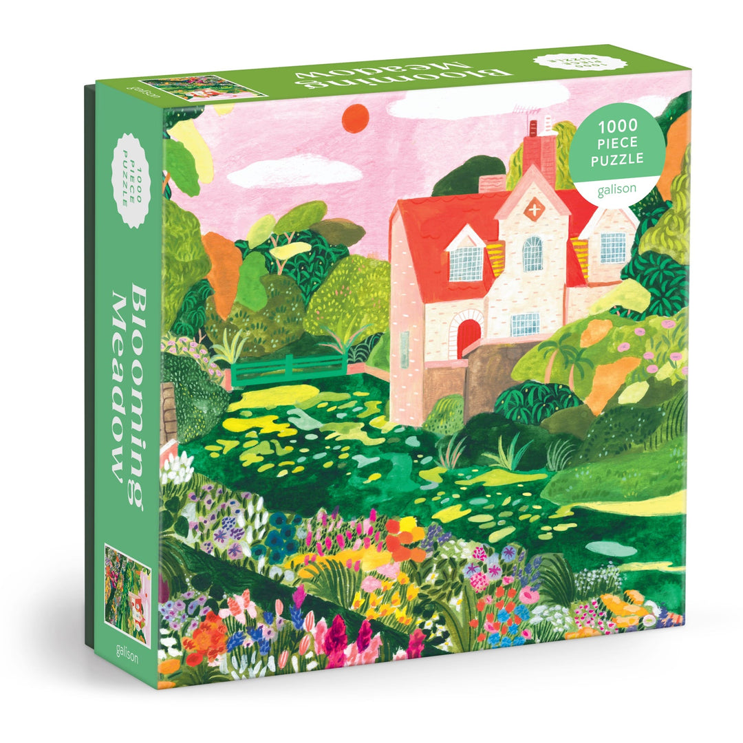 The Blooming Meadow 1000 Piece Puzzle by Flore Cousseran features vibrant cottage artwork with blooming flowers, green trees, and a garden beneath a pink sky.