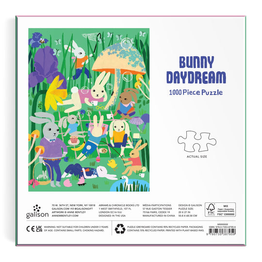Illustration of rabbits having a picnic in a vibrant meadow with flowers, umbrellas, and tea sets. Text reads "Bunny Daydream 1000 Piece Puzzle" with Anne Bentley branding and safety information.