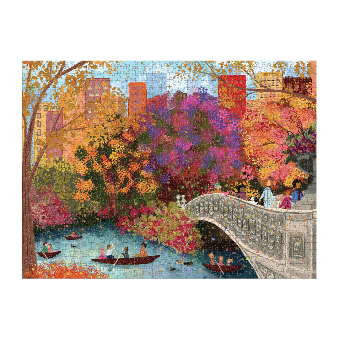 The Joy Laforme Autumn on Bow Bridge 1000 Piece Puzzle by Joy Laforme features a colorful autumn scene of people boating and strolling across Bow Bridge with vibrant trees and city buildings in the background—ideal for your next puzzle session.