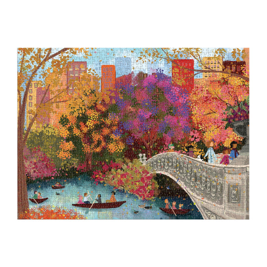 The Joy Laforme Autumn on Bow Bridge 1000 Piece Puzzle by Joy Laforme features a colorful autumn scene of people boating and strolling across Bow Bridge with vibrant trees and city buildings in the background—ideal for your next puzzle session.