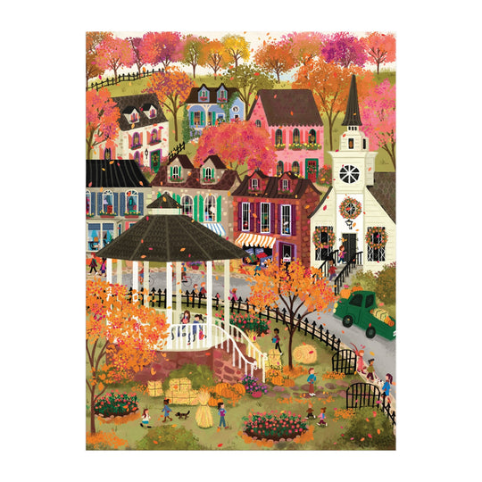 The Joy Laforme Falls Hollow 1000 Piece Puzzle by Joy Laforme features a lively autumn village with people near a white gazebo, colorful houses, a tall-steepled church, pumpkins, hay bales, and trees in vibrant orange and pink.