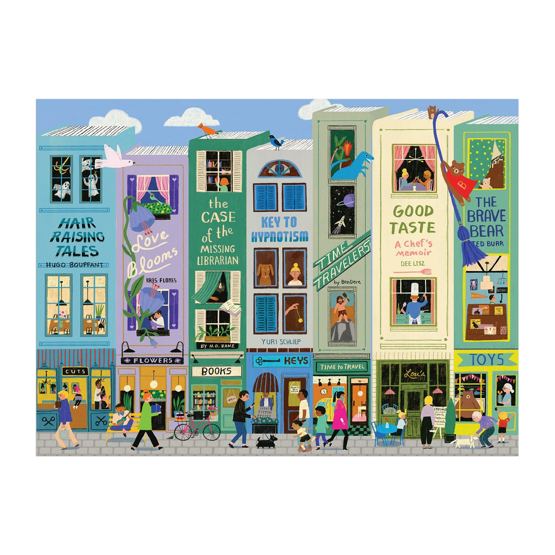 Colorful illustration from Anne Bentley’s Main Street Books 1000 Piece Puzzle: a lively city street with shops, apartments, and signs like “Time Travelers,” “Good Taste,” and “The Brave Bear.” People stroll while cats and birds perch on window sills.