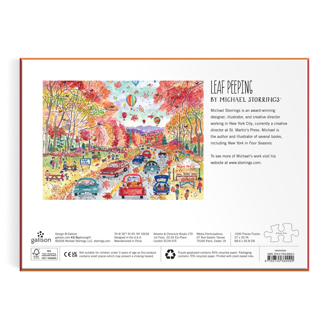 Back of the Michael Storrings Leaf Peeping 1000 Piece Puzzle box shows a vibrant fall scene with cars on a leaf-covered road and autumn trees. Artist details and description are printed on the right. Brand: Michael Storrings.