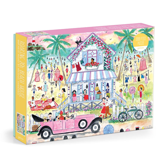 The Michael Storrings Roaring 20s Beach House 1000 Piece Puzzle features a vibrant beach scene with people in vintage outfits, a pink stilt house, palm trees, and a classic pink convertible.
