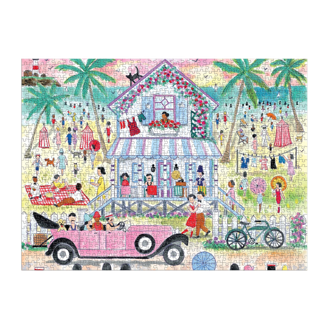 The Michael Storrings Roaring 20s Beach House 1000 Piece Puzzle features a vibrant beach scene with a pink vintage car, bicycle, stilt house, palm trees, and beachgoers enjoying the sun.
