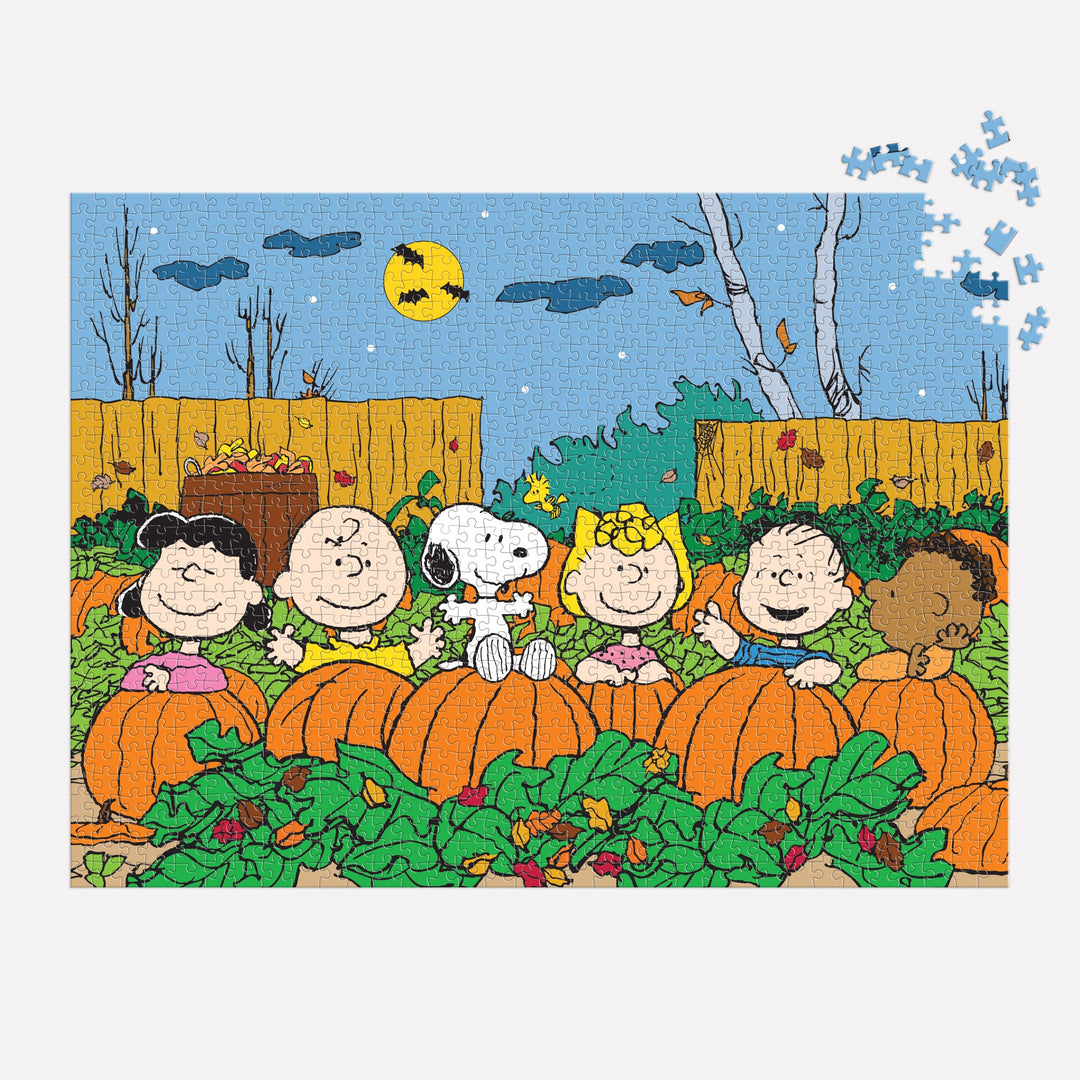 The Peanuts Great Pumpkin 1000 Piece Puzzle by Peanuts Worldwide, LLC features Schulz’s classic characters in a pumpkin patch under a night sky with a full moon and bats, with just a few pieces missing from the top right corner.