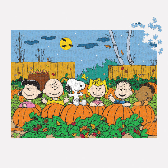 The Peanuts Great Pumpkin 1000 Piece Puzzle by Peanuts Worldwide, LLC features Schulz’s classic characters in a pumpkin patch under a night sky with a full moon and bats, with just a few pieces missing from the top right corner.